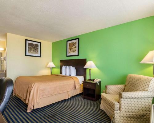 a hotel room with a bed and a chair at Quality Inn Liberal in Liberal