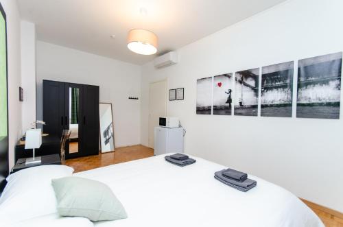 ミラノにあるGreen Roomの大きな白いベッドといくつかの絵が置かれた白い寝室