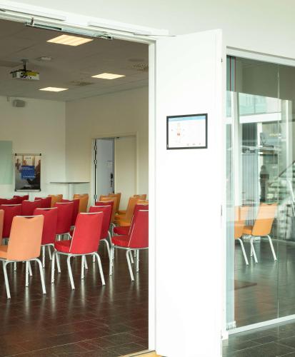a conference room with red chairs and tables at Radisson Blu Airport Terminal Hotel in Arlanda