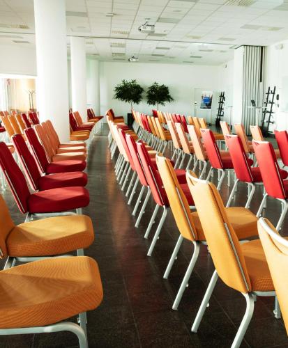 a row of chairs with red and orange seats at Radisson Blu Airport Terminal Hotel in Arlanda
