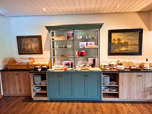 a room with a counter with plates and dishes at Peters - das Genusshotel in der Wingst in Wingst