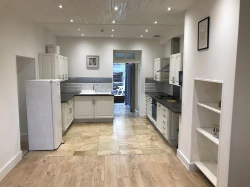 une grande cuisine avec des appareils blancs et du parquet dans l'établissement Logement Montret, à Montret