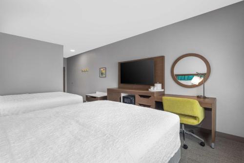 a hotel room with two beds and a desk and a mirror at Hampton Inn & Suites Bakersfield Central in Bakersfield