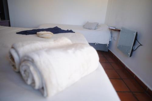 two beds in a room with white walls at Loma Puskana - Hostería in Cachí