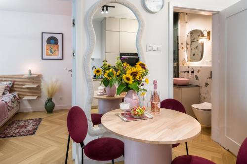 Charming Apartment in a green area- free parking في كراكوف: غرفة طعام مع طاولة وكراسي ومرآة