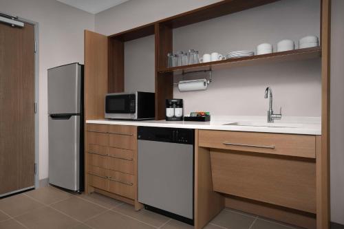 a kitchen with a sink and a refrigerator at Home2 Suites By Hilton Phoenix North Happy Valley in Phoenix