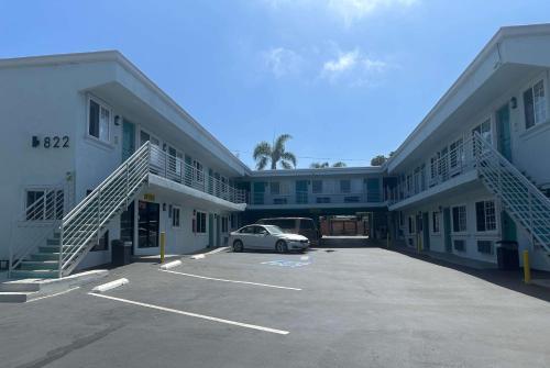 a car parked in a parking lot between two buildings at Super 8 by Wyndham Oceanside Downtown in Oceanside