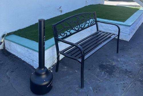 a black bench sitting in front of a sidx sidx sidx at Super 8 by Wyndham Oceanside Downtown in Oceanside