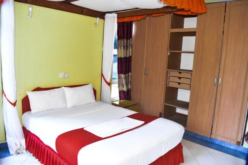 a bedroom with a bed with a red and white blanket at Azul Margarita Beach Resort in Bamburi
