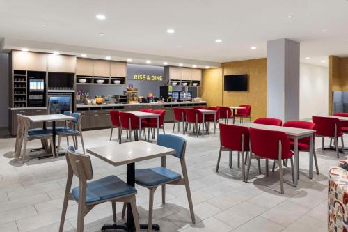 a restaurant with tables and chairs and a counter at Home2 Suites By Hilton East Haven New Haven in East Haven