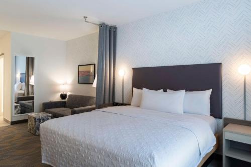 a hotel room with a large bed and a chair at Home2 Suites By Hilton East Haven New Haven in East Haven