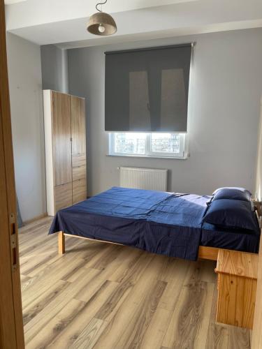 a bedroom with a blue bed and a window at Pirosmani love in Angisa