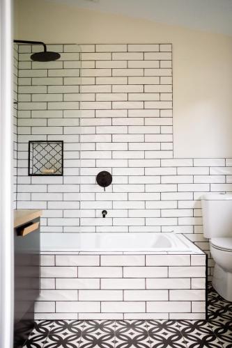 a white bathroom with a tub and a toilet at Jujube in Dromana