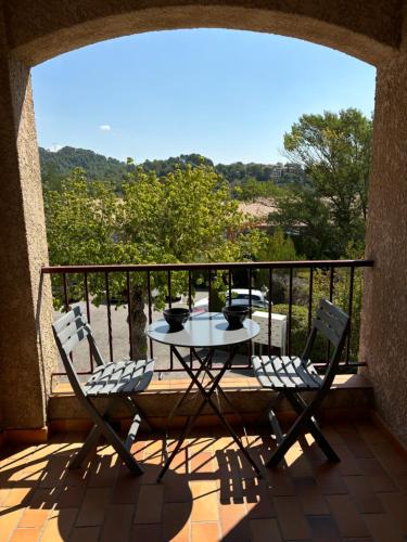 un patio avec une table et des chaises sur un balcon dans l'établissement Appartement - les jardins de Cybèle - Gréoux-Les-Bains, à Gréoux-les-Bains