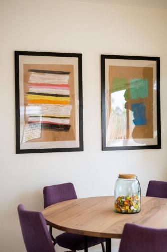 a wooden table with chairs and two paintings on the wall at Jujube in Dromana