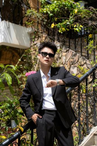 a man wearing a suit and sunglasses leaning on a rail at The Manor Villas Da Lat in Xuan An