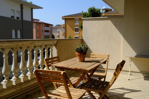 a wooden table and chairs on a balcony with a potted plant at Later in Crema