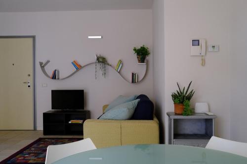 a living room with a yellow couch and a tv at Later in Crema