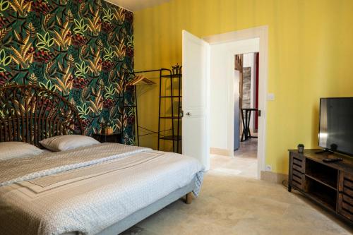 a bedroom with a bed and a tv in it at "Le 35" Maison rénovée avec jardin proche centre in Lamotte-Beuvron