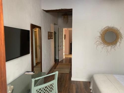 a room with a bed and a television on a wall at Patios del Agua in El Puerto de Santa María