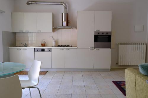 a white kitchen with white cabinets and a table at Later in Crema