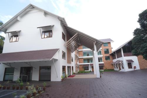a white building with a black roof at Hotel Devalokam in Trittāla