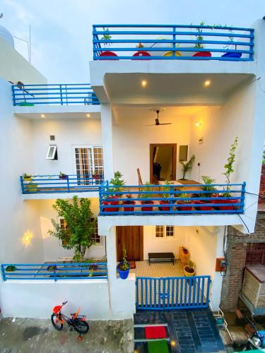 a house with blue balconies and a motorcycle parked in front at Comfort & Cozy, Villa in Orchha