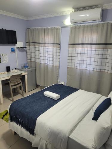a bedroom with a large bed with a desk and a desk at The Zion Hill in East London