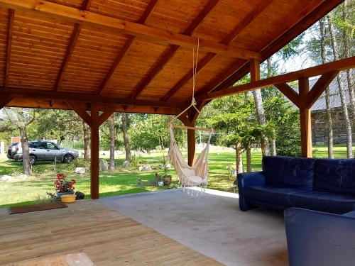 a pavilion with a blue couch and a hammock at Dom Gościnny Hansel & Gretel in Kallinowen