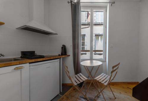 a kitchen with two chairs and a table at Cosy & Duplex - Appartements au coeur de la vieille Ville in Clermont-Ferrand