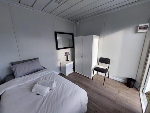 a bedroom with a white bed and a chair at Ezee Camp, Contractor Accommodation in Palma