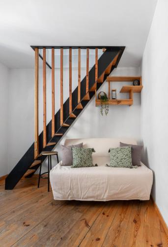 un salon avec un canapé et un escalier dans l'établissement Cosy & Duplex - Appartements au coeur de la vieille Ville, à Clermont-Ferrand