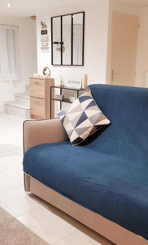 - un canapé bleu avec un oreiller dans le salon dans l'établissement Celies Country Cottage, à Blaru