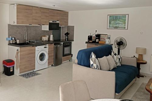 un soggiorno con un divano blu e una cucina di Celies Country Cottage a Blaru