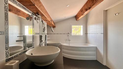 La salle de bains blanche est pourvue de 2 lavabos, d'une baignoire et d'une baignoire. dans l'établissement Villa Les Pariades : 8 Prs, 4 ch, Piscine, Vue mer, à Vallauris