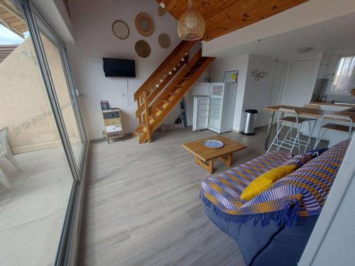 un salon avec un canapé et un escalier dans l'établissement Duplex climatisé 6 pers, terrasse sud, proche plage, parking privé - FR-1-326-662, à Le Castellas