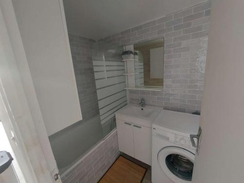 une salle de bain avec un lavabo et une machine à laver dans l'établissement Duplex climatisé 6 pers, terrasse sud, proche plage, parking privé - FR-1-326-662, à Le Castellas