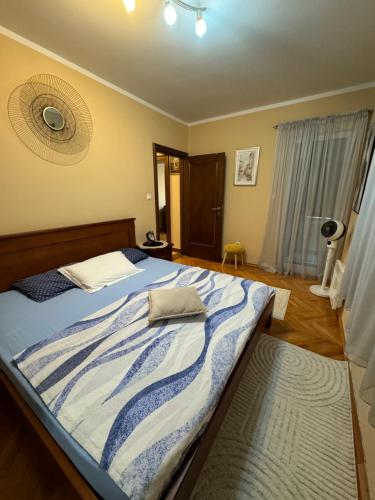 a bedroom with a bed with a blue and white blanket at Apartman Nina in Kotor