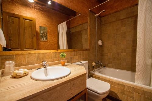 a bathroom with a sink and a toilet and a tub at Hotelapartamentos Torres in Selorio