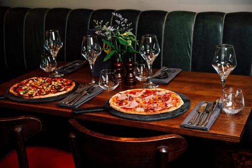 two pizzas sitting on top of a wooden table at The George in Hathersage