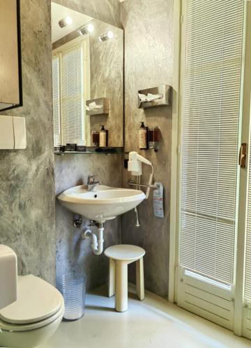 a bathroom with a sink and a toilet at Hotel Ancora in Verbania