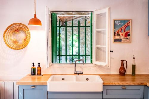 une cuisine avec un évier et une fenêtre dans l'établissement Collection Sojourn - Le Mas, à Vacquières