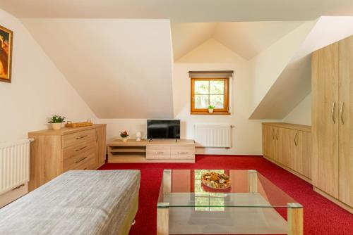 a attic room with a bed and a tv at Wellness hotel Chata Jana in Lopeník