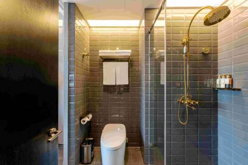 a bathroom with a toilet and a glass shower at Crystal Hotel Shanghai North Sichuan Road on the Bund in Shanghai