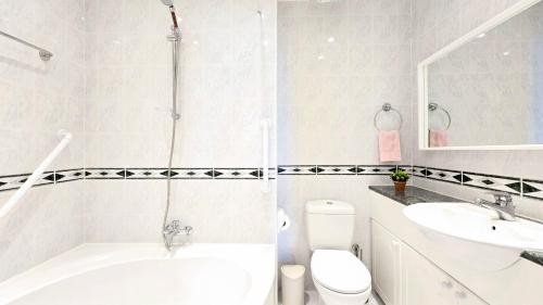 a bathroom with a tub and a sink and a toilet at CSS Cute Superior King's Palace in Paphos City