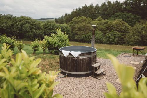 a large wooden barrel with a table and a bench at Brecon by Wigwam Holidays in Brecon