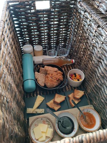 a basket full of cheese and bread and other foods at Une escale gourmande in Eyzerac