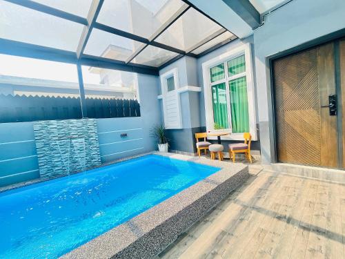 a swimming pool in a house with a table and chairs at Resthouse Asyura in Malacca