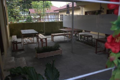 a patio with tables and chairs and a table at Tange Guest House in Ruteng