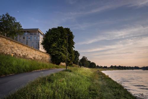 a building on the side of a road next to a river at Riverside Aparthotel Cracow in Kraków